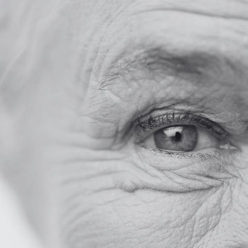 A black and white image of eye of an old person with wrinkles on his skin. For this we have Herbstonic Anti-Aging Dry Facial Pack.